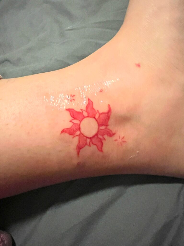 tattoo in red ink of sun